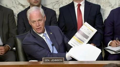 Sen. Johnson holds up redacted documents at Golf hearing